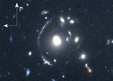 Фотографијата од младата галаксија SDSS090122.37+181432.3 е изобличена поради ефектот на гравитациска леќа (искривување на светлината која ја добиваме од далечен објект при поминување во близина на други масивни објекти). Извор: NASA/STScI; S. Allam and team; and the Master Lens Database (masterlens.org), L. A. Moustakas, K. Stewart, et al (2014).